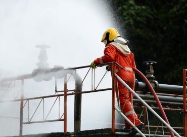 Fire fighter team on training with gas and oil fire at pipe line and valve spray jet water